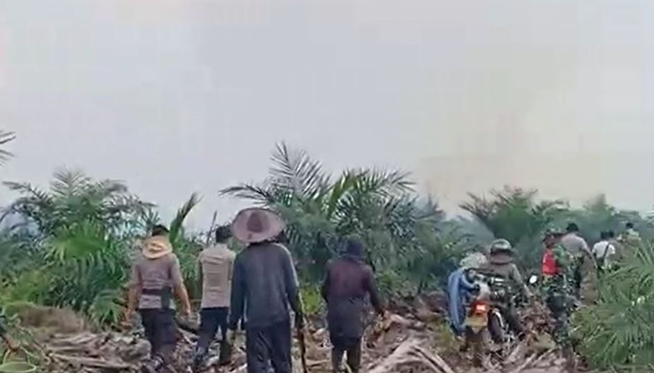 Bersama TNI dan masyarakat, anggota kepolisian berupaya memadamkan kebakaran lahan di salah satu perkebunan sawit di wilayah Sanggau. Foto: dok