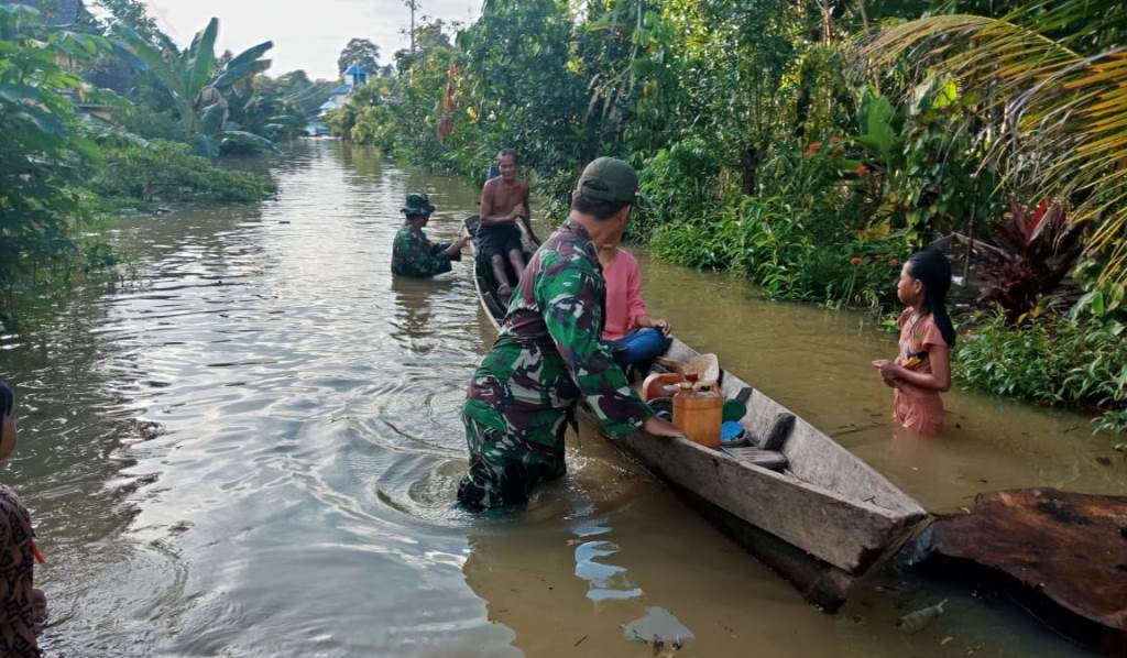 Anggota Koramil saat sedang membantu evakuasi masyarakat yang terdampak banjir.