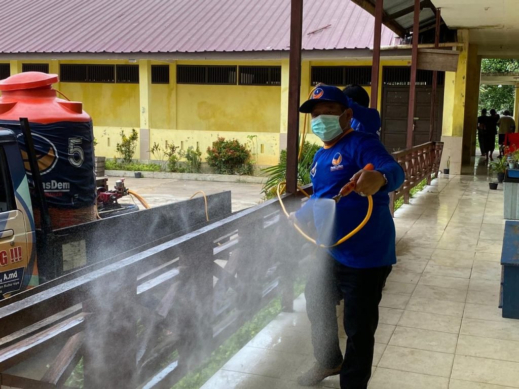 Anggota Fraksi Nasdem DPRD Kubu Raya Jhon Saimima saat melakukan penyemprotan disinfektan di salah satu sekolah