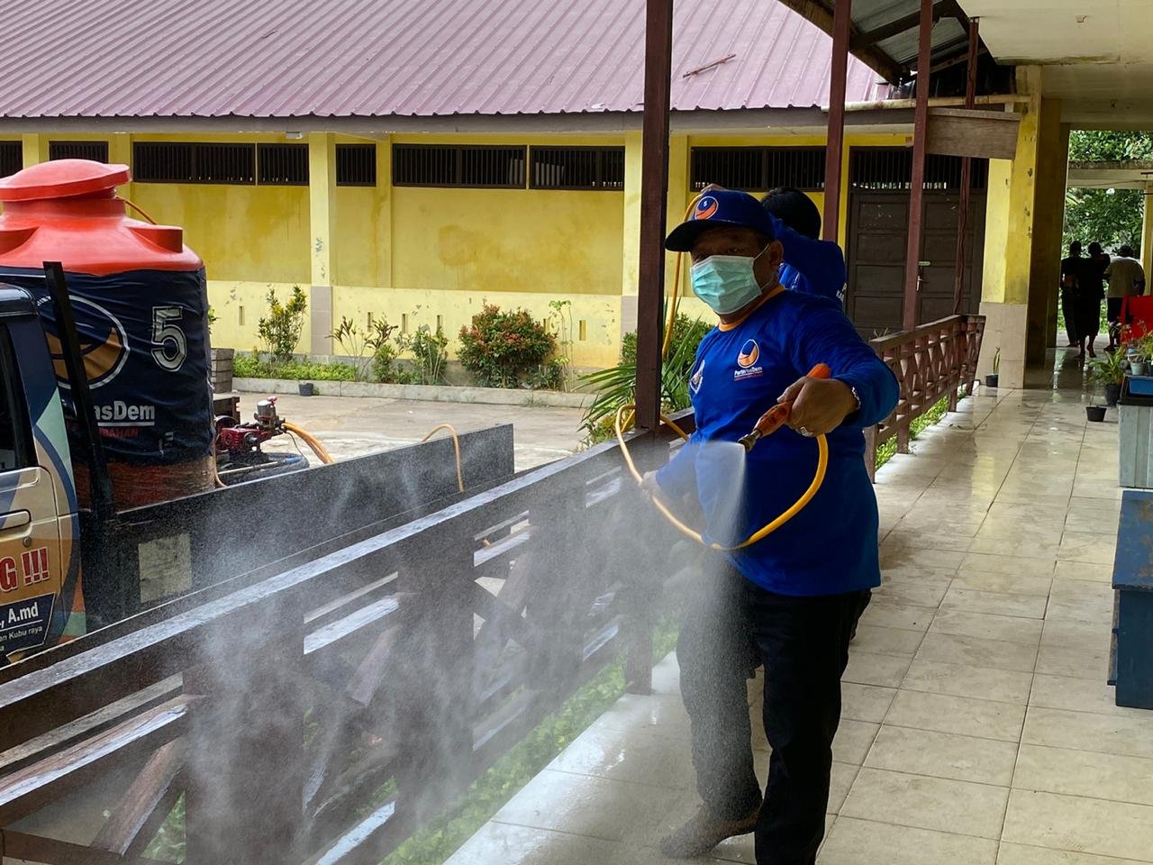 Anggota Fraksi Nasdem DPRD Kubu Raya Jhon Saimima saat melakukan penyemprotan disinfektan di salah satu sekolah
