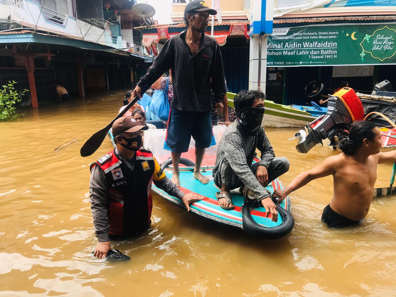 Anggota kepolisian saat bantu evakuasi warga yang terdampak banjir.