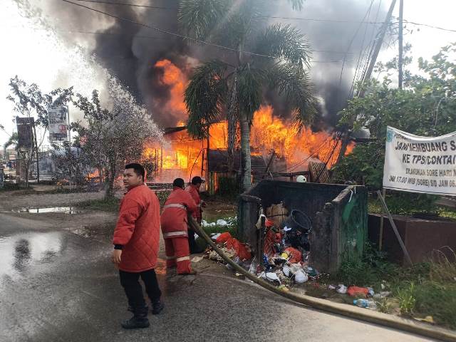 Petugas Damkar sedang berupaya memadamkan api yang menghanguskan sembilan kios.