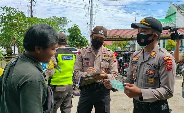 Kapolsek Sui Raya saat memberikan masker kepada pengendara yang terjaring operasi yustisi.