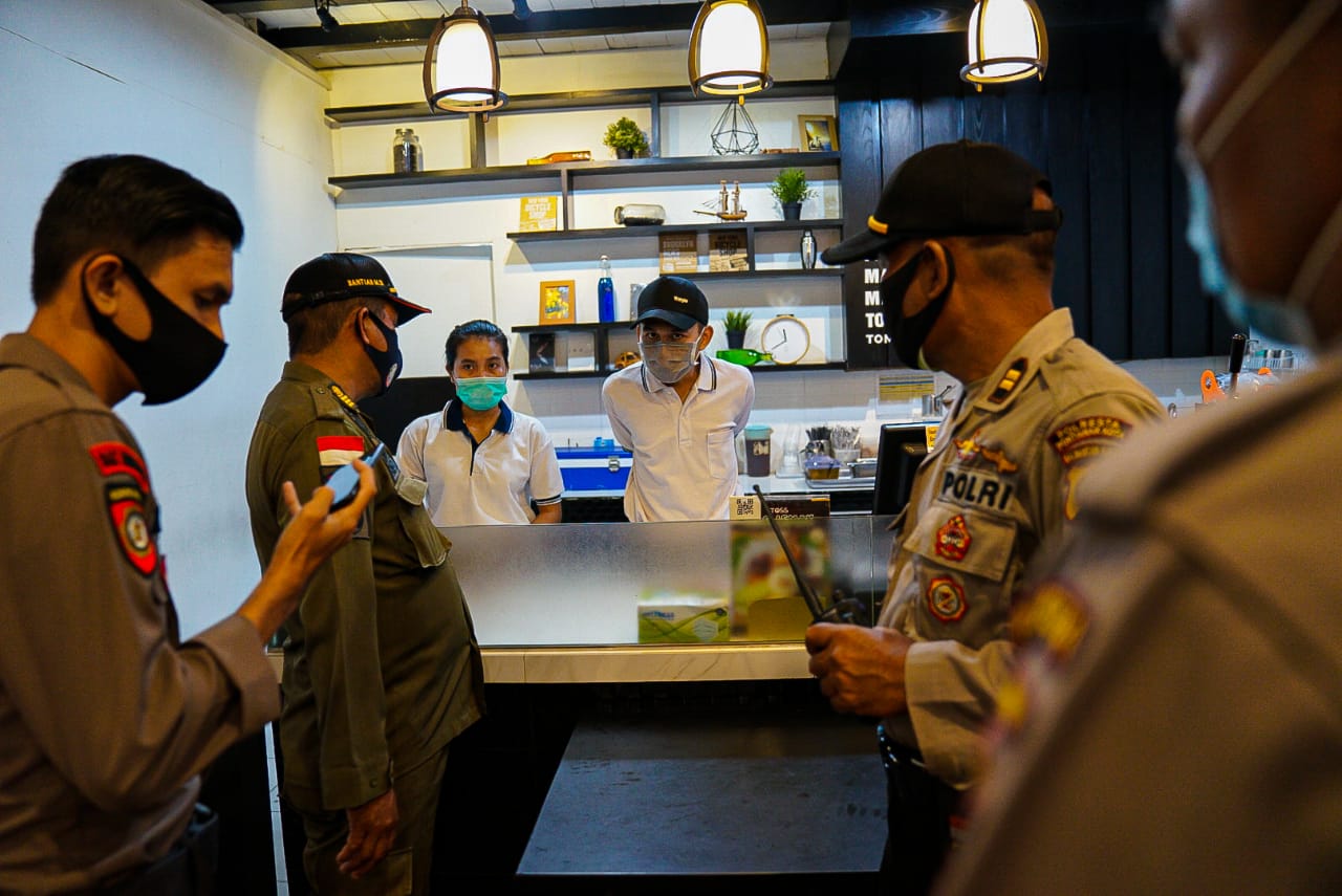 Petugas gabungan saat melakukan penyisiran terhadap sejumlah tempat usaha di Pontianak yang telah memberlakukan pembatasan aktifitas jama malam.