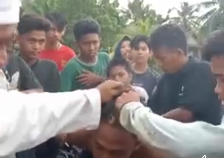 Salah satu maling yang berhasil ditangkap warga dan motornya dibakar massa.