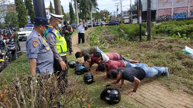 Personel gabungan saat melakukan razia terhadap pengendara yang melanggar prokes dikenakan sanksi sosial.
