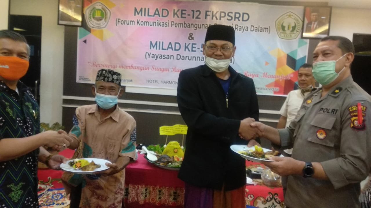 Ketua FKPSRD dan Ketua YDR memberikan tumpeng kepada Sekda dan perwakilan dari Polres Kubu Raya saat memperingati milad FKPSRD dan YDR.