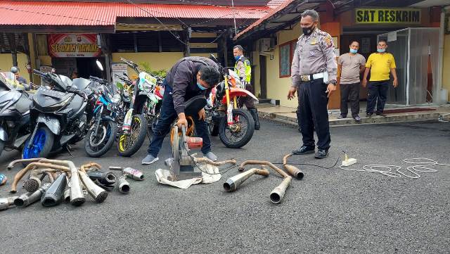 Salah seorang pemilik motor sedang memotong knalpot racing yang digunakannya sebagai sanksi telah menggunakan knalpot tidak standar.