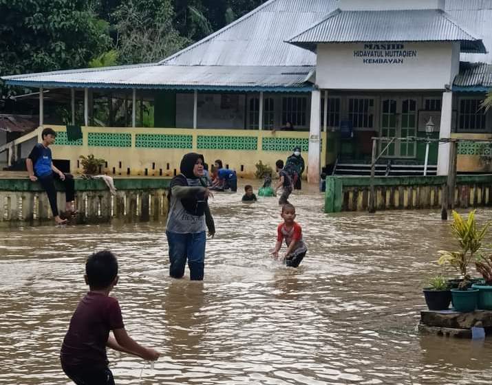 Warga dan anak-anak bermain di tengah banjir yang melanda Kecamatan Kembayan.