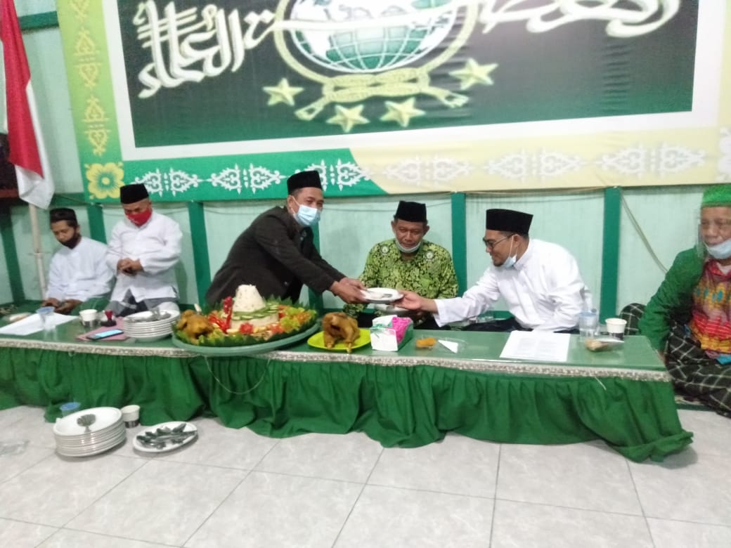 Penyerahan potongan tumpeng dari Ketua Tanfidziyah NU kepada Ketua Dewan Suriyah PCNU.