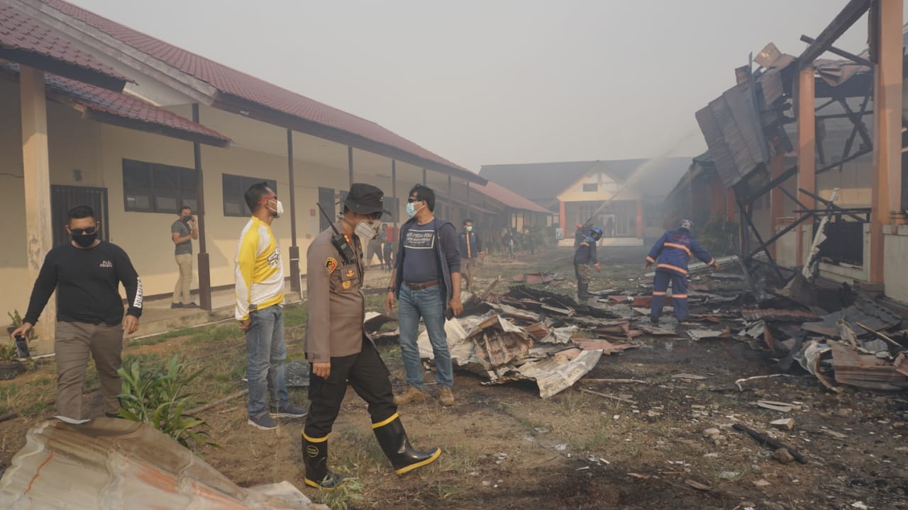 Kapolres bersama tim gabungan saat memadamkan api yang menghanguskan empat ruangan di SMK Negeri 1 Sui Raya.