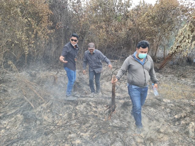 Anggota Sat Reskrim saat melakukan penyelidikan di lokasi karhutla yang dibakar oleh warga setempat.