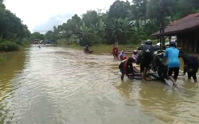 Warga saat menaikkan kendaraannya menggunakan rakit, Jumat (5/2).