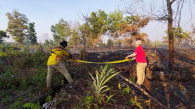 Kasubdit 4 Tipiter Ditreskrimsus Polda Kalbar bersama anggota saat memasang garis polisi di lahan yang dibakar sengaja di Pontianak