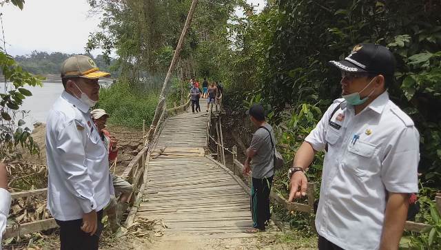 Kadis BM dan SDA Sanggau didampingi Kepala Desa Inggis Sunardi meninjau jembatan Engkakal