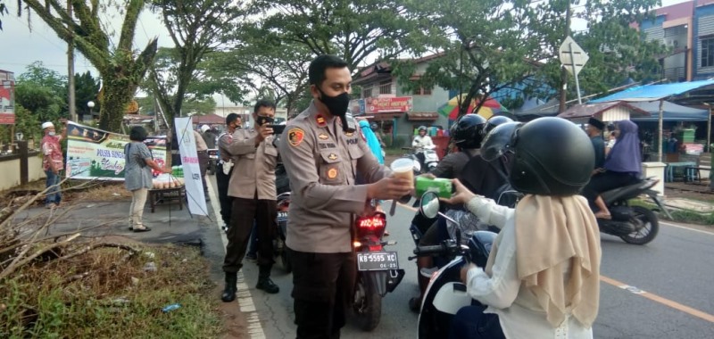 Kapolsek Sui Ambawang saat membagikan takjil kepada masyarakat pengguna jalan.