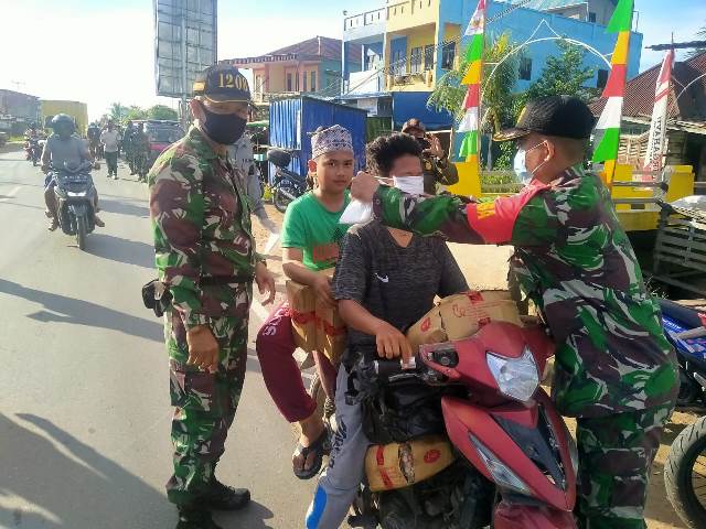 Danramil Pemangkat saat membagikan masker kepada pengunjung di Pasar Pemangkat