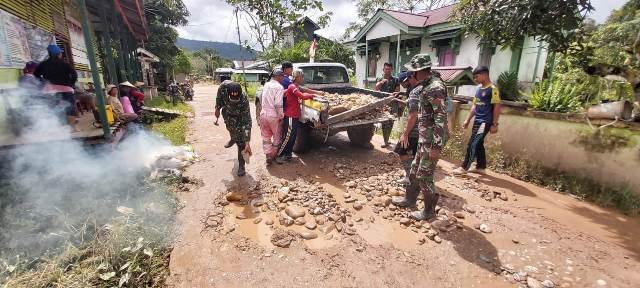 Personel Satgas Pamtas Yonif 407/Padma Kusuma gotong royong bersama warga Desa Langau Puring Kencana memperbaiki jalan rusak