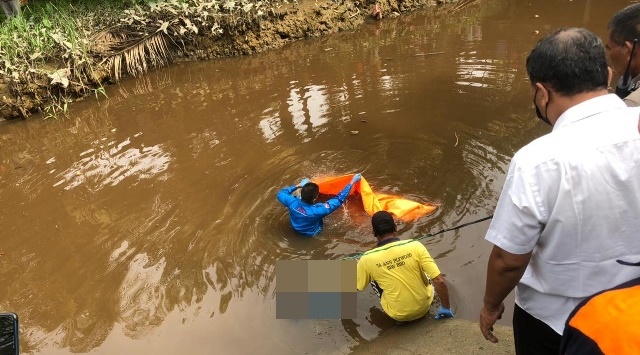 Petugas kepolisian sedang melakukan evakuasi terhadap mayat yang ditemukan mengapiung di sungai oleh pembuat batako