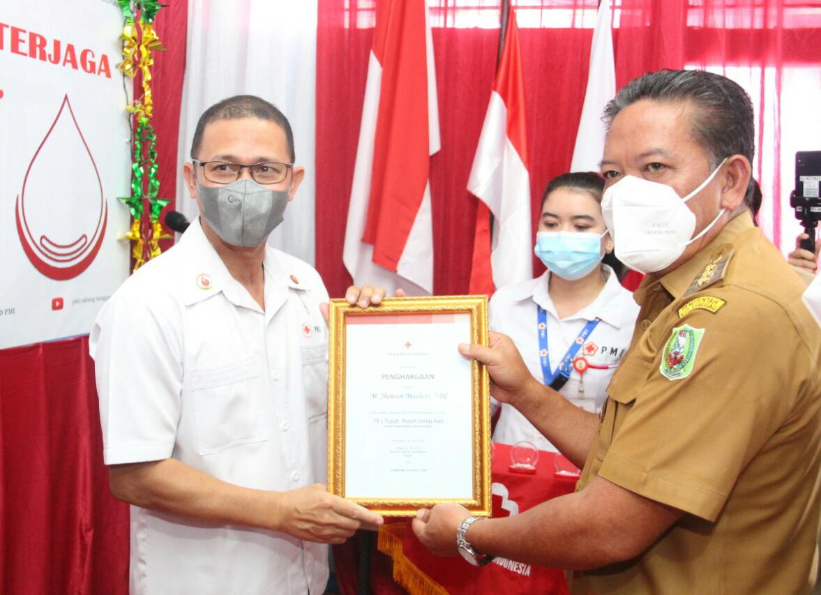 Bupati Sanggau menyerahkan penghargaan kepada sukarelawan donor darah di peringatan Hari Donor Darah Sedunia