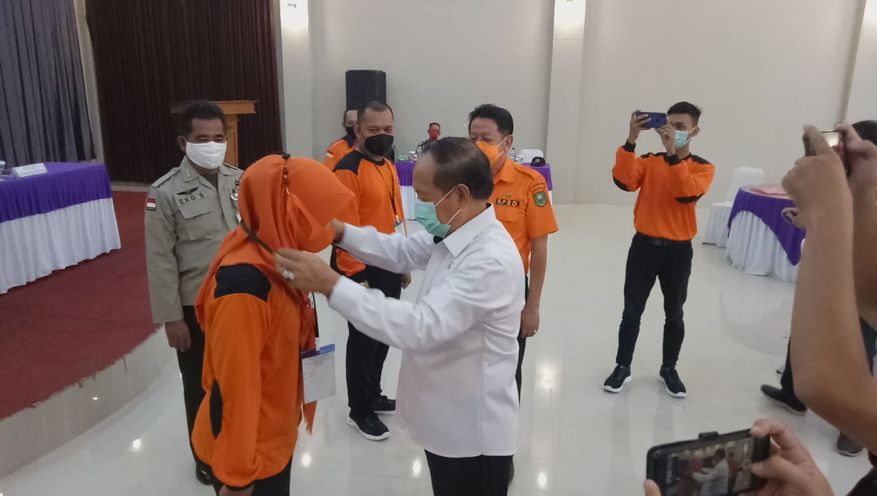 Wakil Bupati didampingi Kepala Pelaksana BPBD Sanggau mengalungkan tanda peserta penguatan kapasitas kawasan untuk pencegahan dan kesiapsiagaan bencana