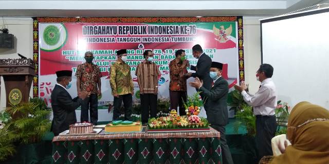 Ketua PN Sintang memberikan potongan tumpeng kepada hakim yang telah pensiun bertepatan HUT ke-76 Mahkamah Agung RI.