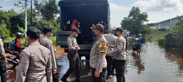 Personel Polres Melawi saat membantu warga yang melintasi jalan dengan menggunakan truk Dalmas.