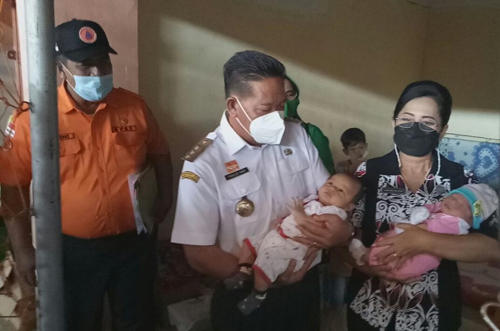 Bupati dan Ketua TP PKK Sanggau menggendong bayi yang lahir di posko pengungsian