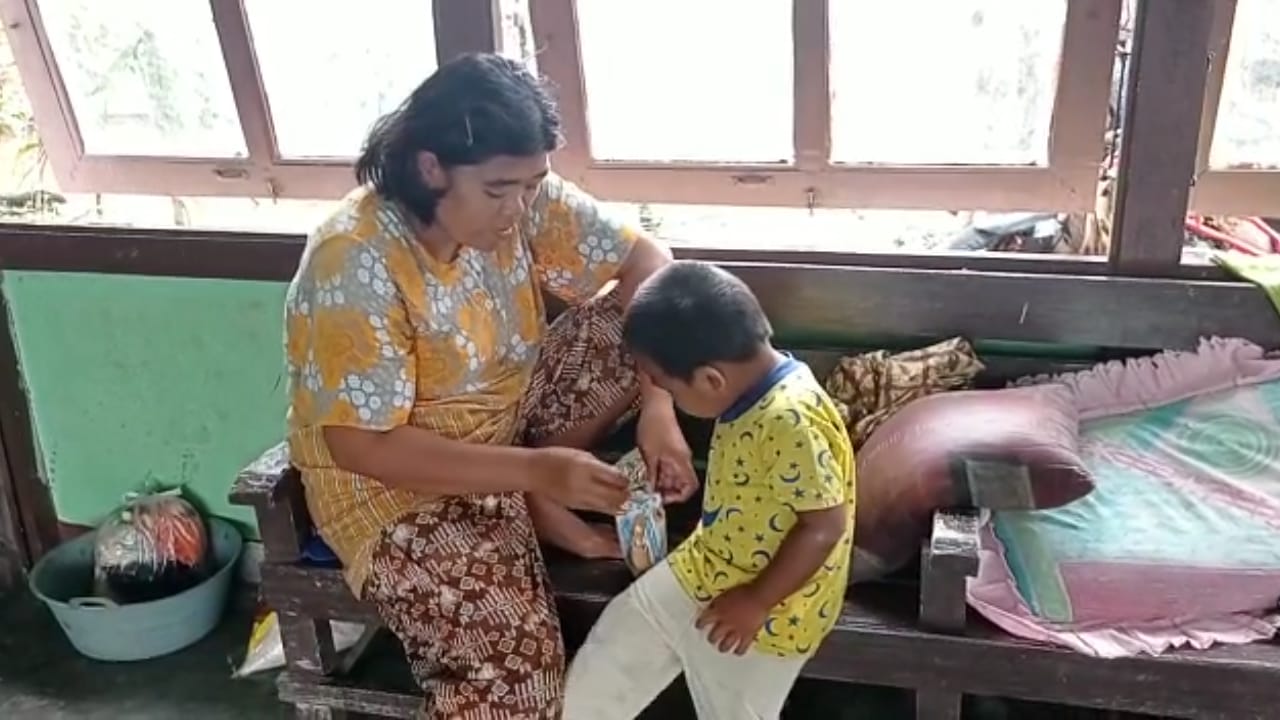 Seorang ibu di pengungsian Balai Desa Semuntai terpaksa memberi makan anaknya dengan mie instan, Minggu (7/11).