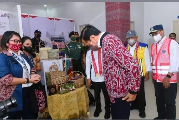 Presiden RI Joko Widodo saat mengenakan jaket bomber manuk Sintang yang dijelaskan oleh Ernawati Sekretaris Dinas Perindustrian, Perdagangan, Koperasi dan Usaha Kecil Menengah Kabupaten Sintang.