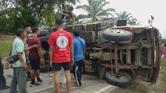 Kondisi truk yang terguling lantaran mengalami pecah ban.