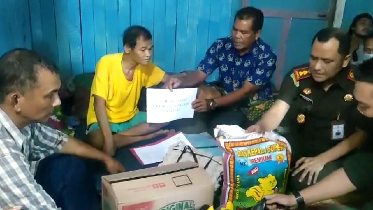 Kepala Kejaksaan Negeri Sanggau menyerahkan bantuan sembako kepada Siyot, pelaku percobaan pencurian di PT. SJAL yang tuntutan hukumnya dihentikan.