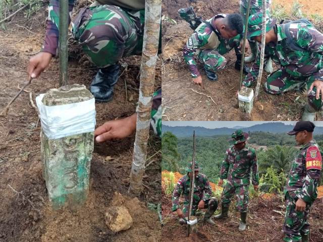 Personel TNI sedang melakukan perbaikan terhadap patok batas Indonesia yang dirusak perusahaan sawit Malaysia menggunakan eksavator.