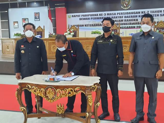 Ketua DPRD menandatangani Berita Acara LKPj Bupati Tahun Anggaran 2021 disakaikan Bupati dan Pimpinan DPRD saat rapat paripurna LKPJ TA 2021.