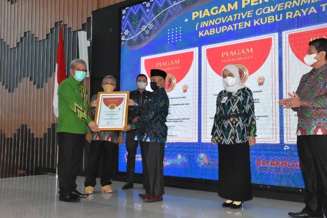 Sekda Kalbar mewakili Gubernur Kalbar menyerahkan piagam penghargaan IGA kepada Kepala Dinas Pemdes KubU Raya saat musrenbang RKPD TA 2023.