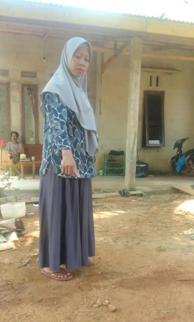 Titin Sumarni ketika menunjukan lokasi motornya yang hilang di depan rumah.