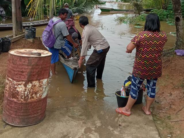 Personel Polsek Ella Polres Melawi sedang membantu warga yang terdampak banjir.