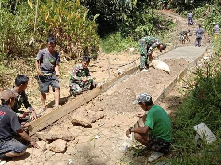 Personel TNI dari Satgas Pamtas Yonif 645/Gardatama Yudha bersama masyarakat gotong royong perbaiki jalan rusak di Dusun Guntembawang, Suruh Tembawang, Entikong Kabupaten Sanggau, perbatasan RI - Malaysia. Foto: ist (pendam)