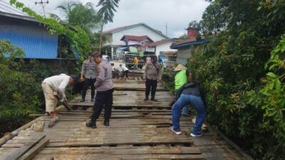 Polsek Sintang Kota mengerahkan anggotanya untuk gotong royong bersama warga perbaiki jembatan yang rusak.