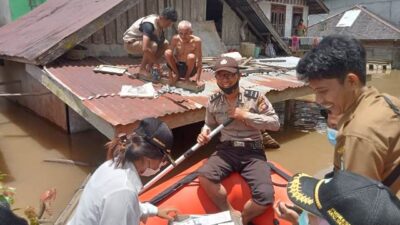 Petugas sedang membantu warga di Kecamatan Serawai yang berada di atas atap rumah lantaran rumahnya terendam banjir sejak dua hari terakhir.