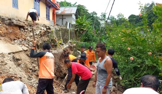 TRC BPBD Sanggau dibantu warga saat membersihkan material longsor di Jalan Gang Natal I akibat runtuhnya barau milik, Senin (3/10). Foto: pek