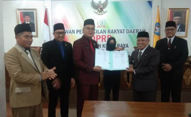 Ketua DPRD Kubu Raya Agus Sudarmansyah menyerahkan pandangan umum fraksi DPRD terhadap tujuh raperda kepada Bupati Kubu Raya Muda Mahendrawan saat rapat paripurna, Selasa (29/11).