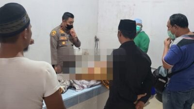 Polisi dan dokter saat sedang malukan visum et repertum terhadap seorang bocah yang tewas di tangan orang tua angkatnya sendiri pada Jumat (18/11) di Kecamatan Singkup Kabupaten Ketapang