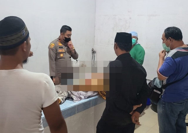 Polisi dan dokter saat sedang malukan visum et repertum terhadap seorang bocah yang tewas di tangan orang tua angkatnya sendiri pada Jumat (18/11) di Kecamatan Singkup Kabupaten Ketapang