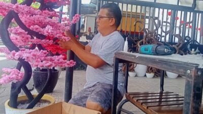Asong seorang pedagang musiman yang sedang merangkai bunga mei hwa. Dari bisnisnya itu ia berhasil mendulang cuan puluhan juta menjelang Imlek.