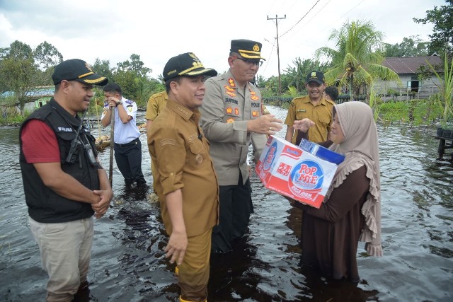 Bupati Sambas Satono didampingi Kapolres Sambas pada Senin (30/1) memberikan bantuan sembakoo dan bahan pangan kepada warga terdampak banjir di Desa Tempapan Hulu Kcamatan Galing.