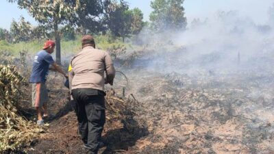 Personel Polsek Batu Ampar dibantu masyarakat seadng memadamkan api yang membakar lahan. Karhutla ini terdeteksi melalui aplikasi lancang kuning.