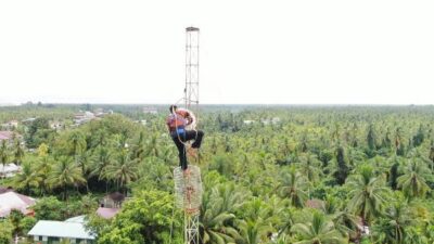 Seorang petugas memasang radio di sebuah tower telekomunikasi yang berdiri di Kabupaten Kubu Raya.