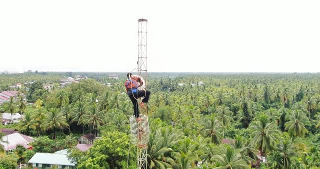 Seorang petugas memasang radio di sebuah tower telekomunikasi yang berdiri di Kabupaten Kubu Raya.