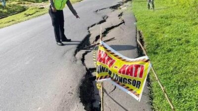 Polisi sedang memasang garis polisi Kamis (16/3) terhadap jalan nasional di tanjakan Semboja yang diduga kuat akibat terjadinya tanah longsor